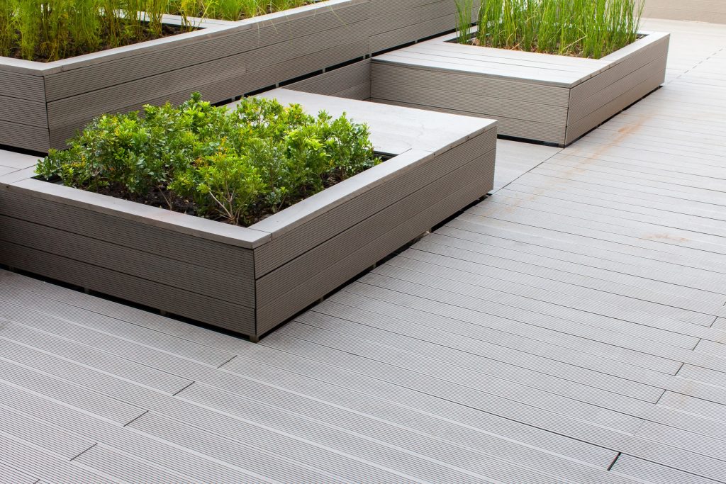 A natural stone retaining wall with matching coping creates a raised planter