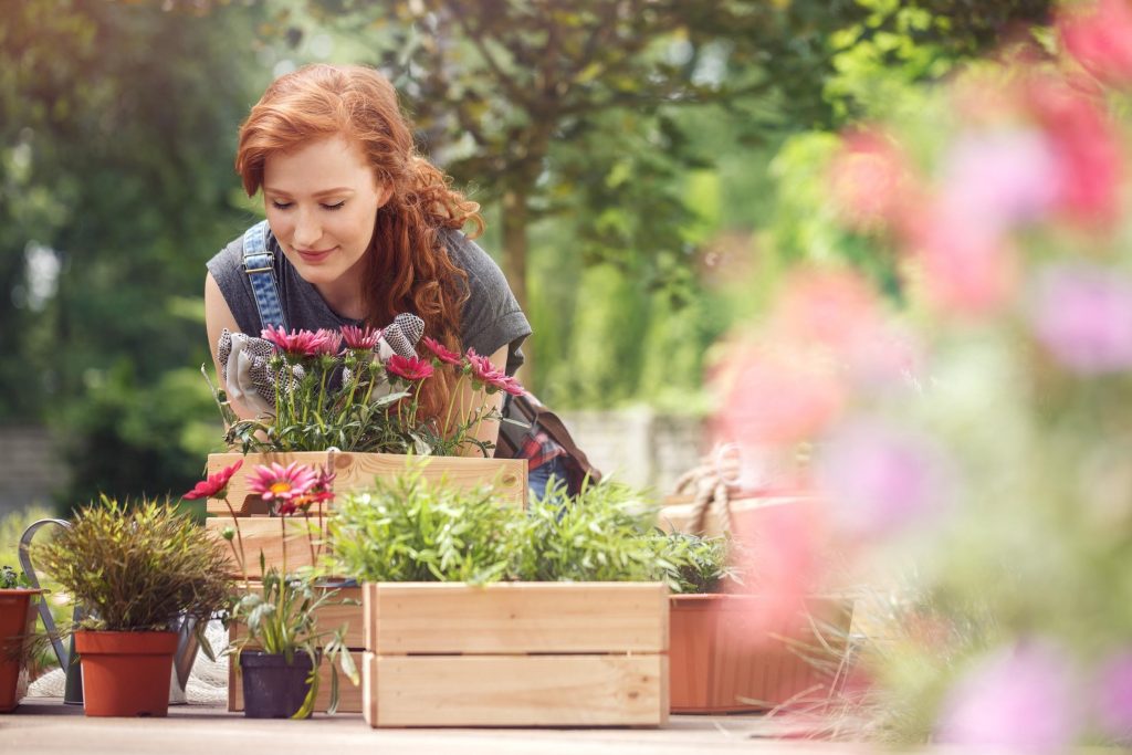 women smelling flowers in garden