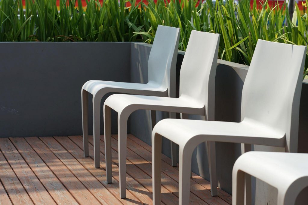 plastic chairs on the timber terrrace with planter box background outdoor