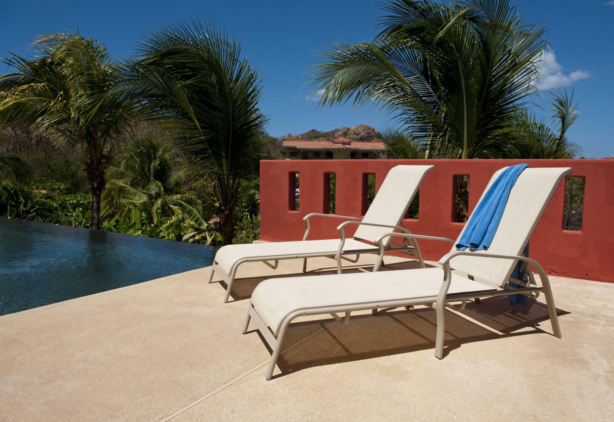Lounge chairs with blue towel on a pool deck