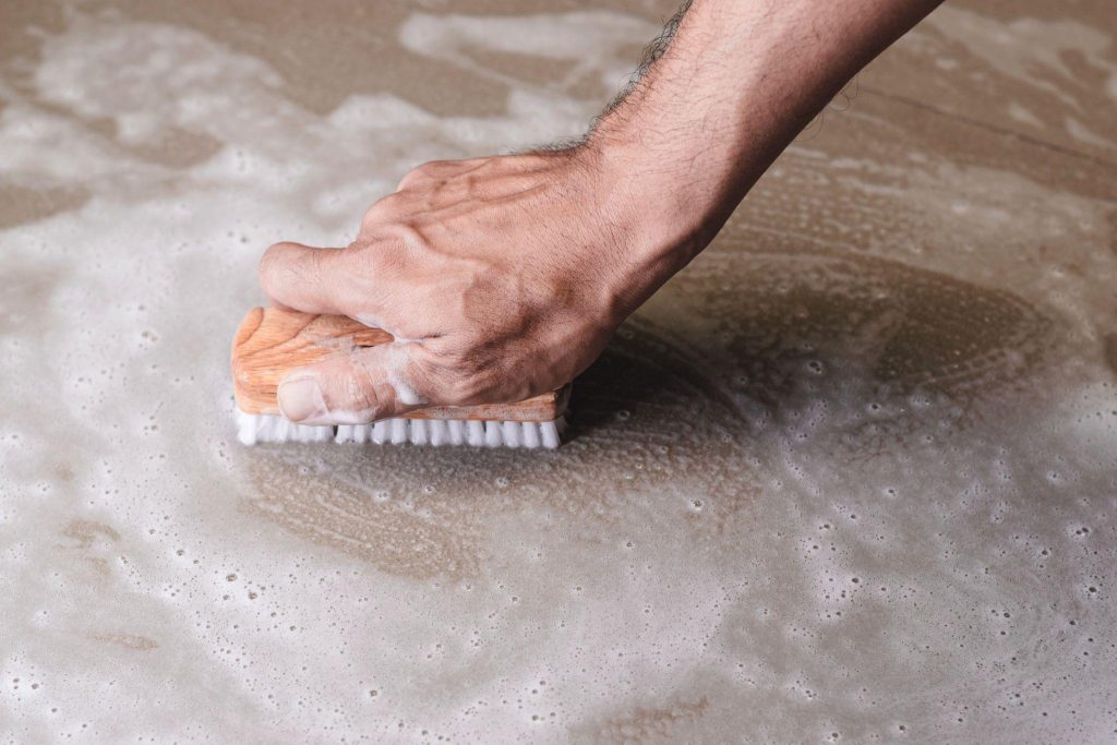 Men's hands are used to convert polishing cleaning on the tile floor.