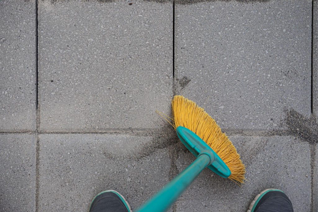 Sweeping Jointing Sand in Paver Patio Installation